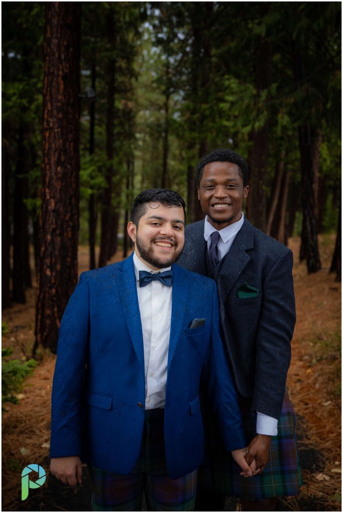 Wedding couple poses and smiles for portrait among trees close to weddinv venue Nakoma Inn in Clio California.