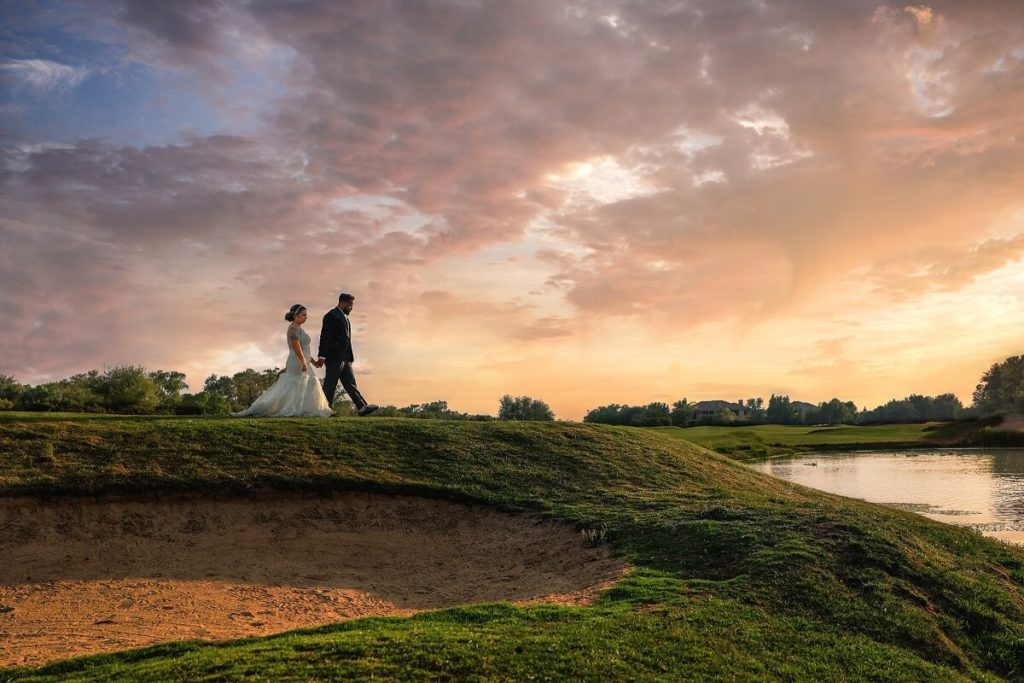 Bride and groom walk towards pond at the top of a hill at Morgan Creek Golf Club. One of the best outdoor wedding venues in Sacramento.